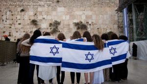 women with israel flag at wall